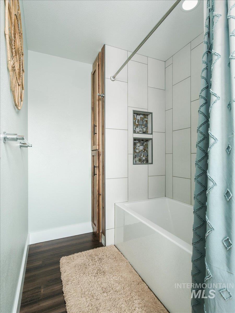 1401 Chokecherry Drive Pocatello, ID 83204 - Photo 28 of 46 Full-size bathtub with white subway tile surround and integrated tiled storage niches