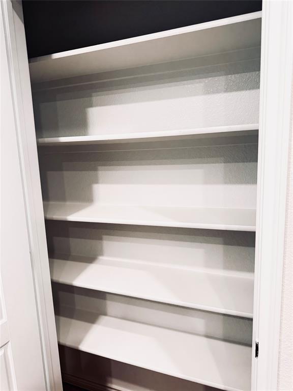 2625 Lewisville Road Celina, TX 75009 - Photo 6 of 7 Built-in shelving unit featuring multiple white shelves and a dark background