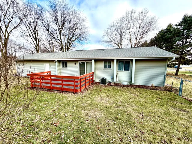 a backyard of a house with wooden fence and large trees
