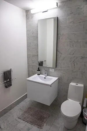 a bathroom with a toilet sink and mirror