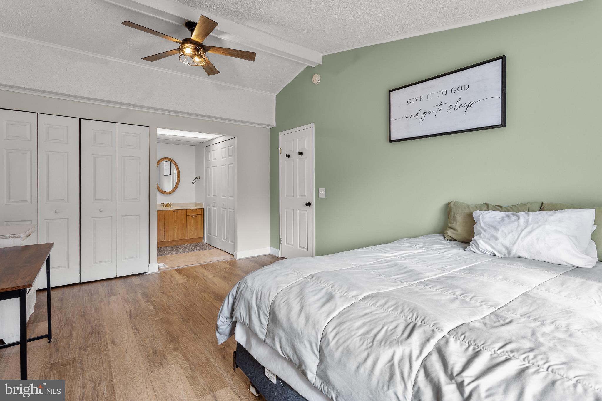 4912 Beech Street Shady Side, MD 20764 - Photo 11 of 42 a bedroom with a large bed and a chandelier