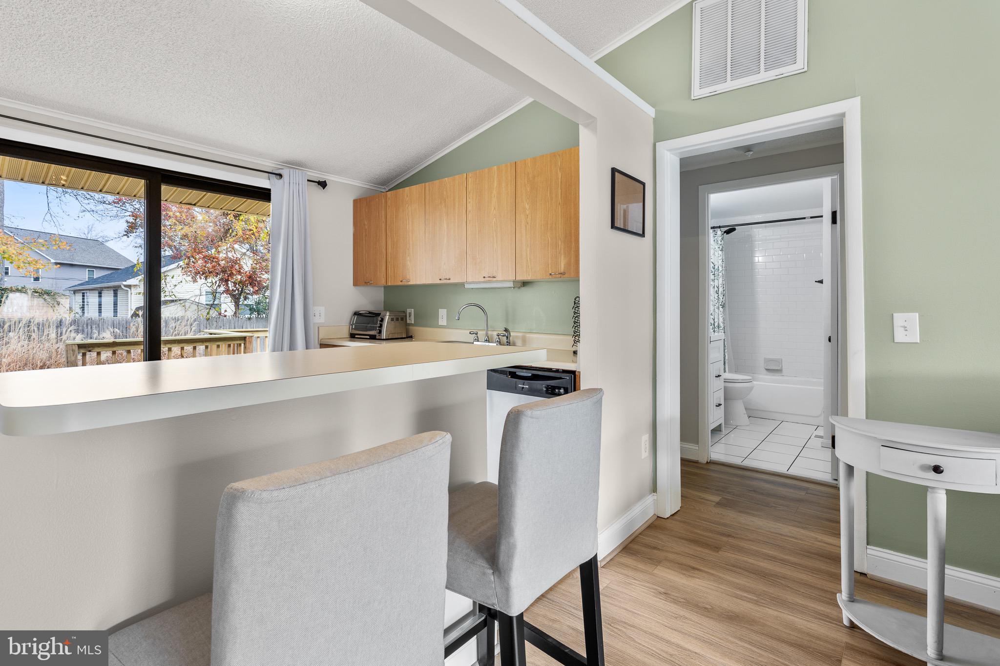 4912 Beech Street Shady Side, MD 20764 - Photo 6 of 42 a kitchen with a table chairs refrigerator and a window