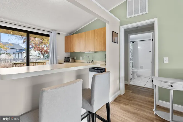 a kitchen with a table chairs refrigerator and a window