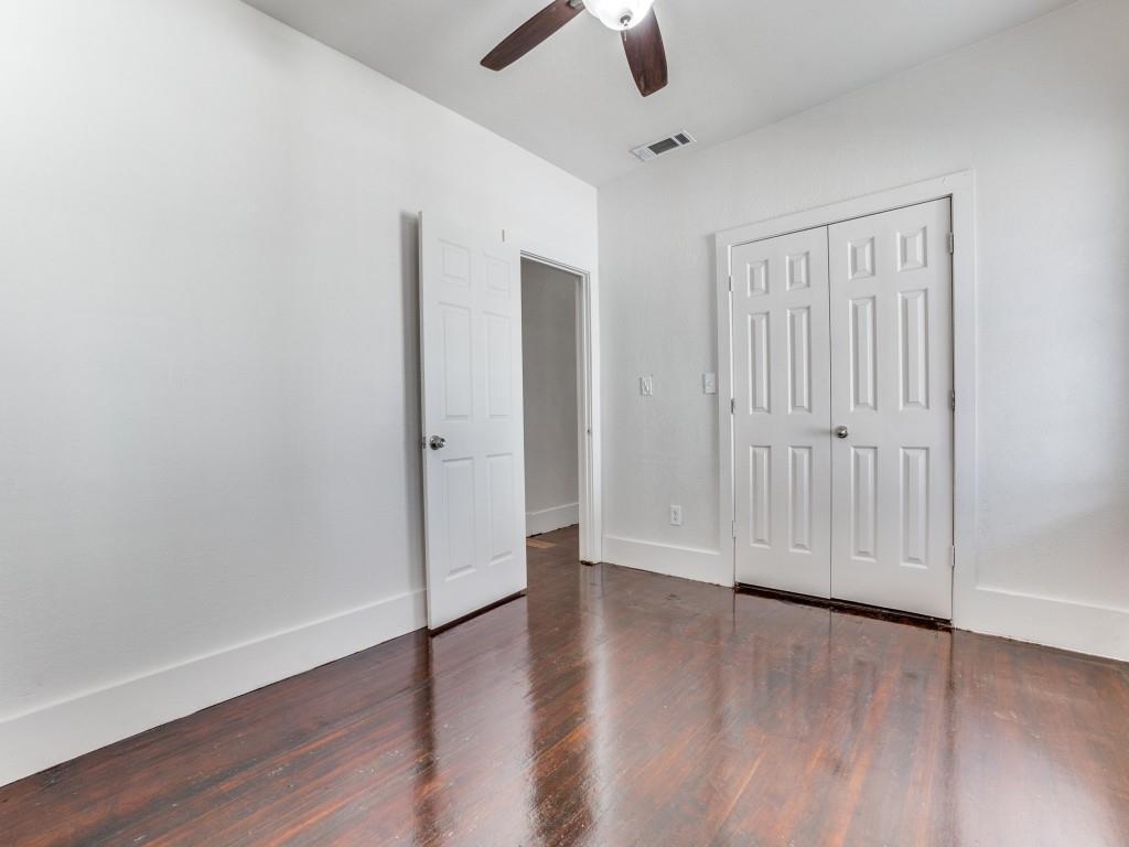 1628 Poplar Street Dallas, TX 75215 - Photo 20 of 20 an empty room with wooden floor chandelier fan and closet area