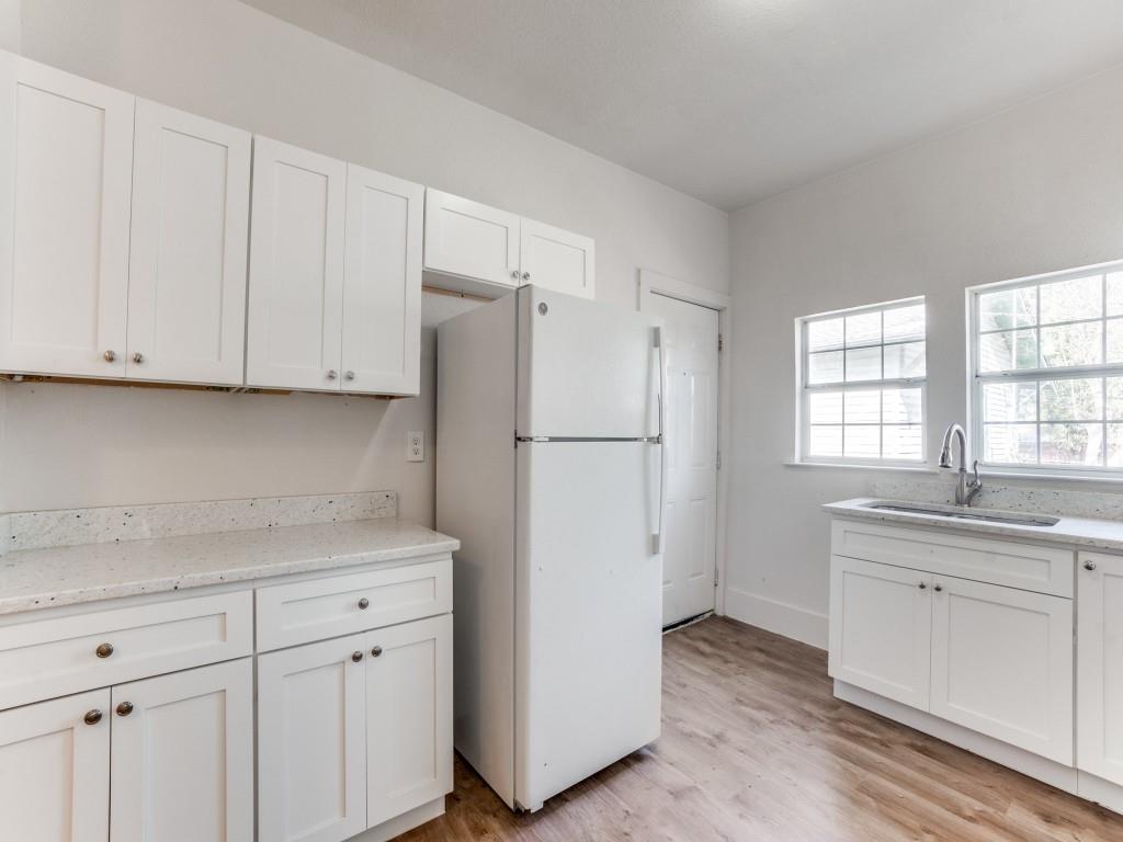1628 Poplar Street Dallas, TX 75215 - Photo 6 of 20 a kitchen with stainless steel appliances white cabinets and a refrigerator