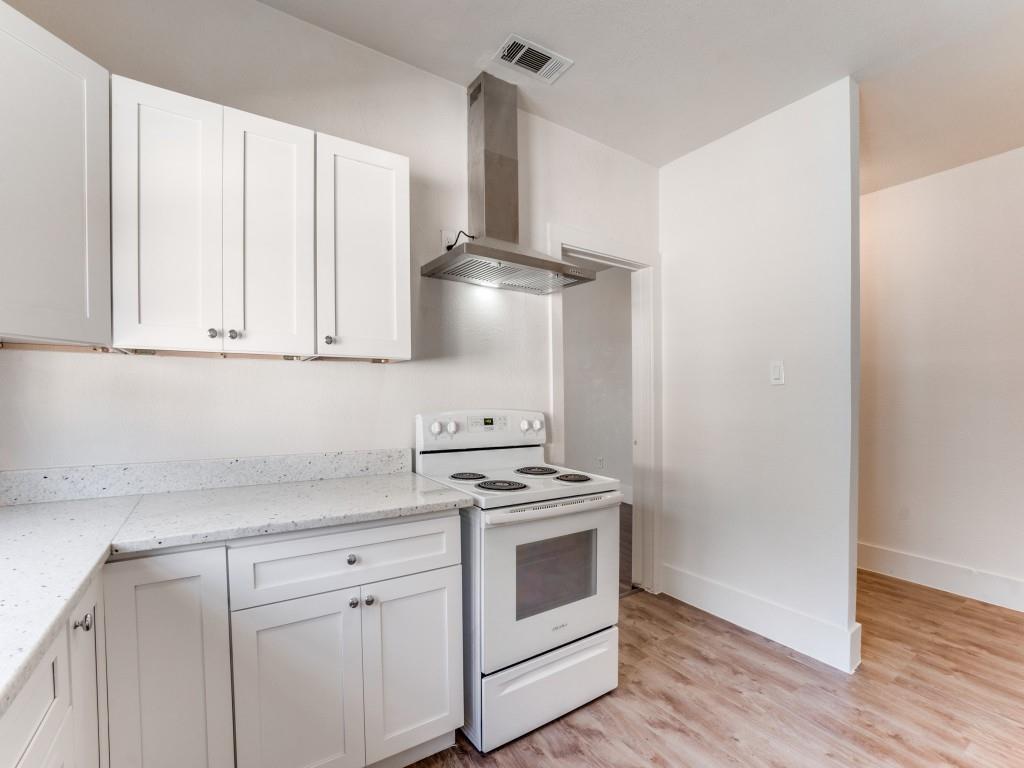 1628 Poplar Street Dallas, TX 75215 - Photo 8 of 20 a kitchen with stainless steel appliances a stove and white cabinets