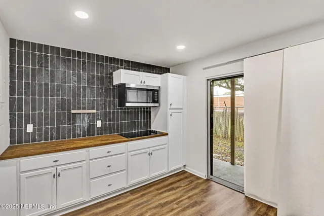 a kitchen with white cabinets and sink