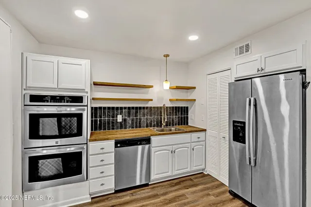 a kitchen with white cabinets and stainless steel appliances