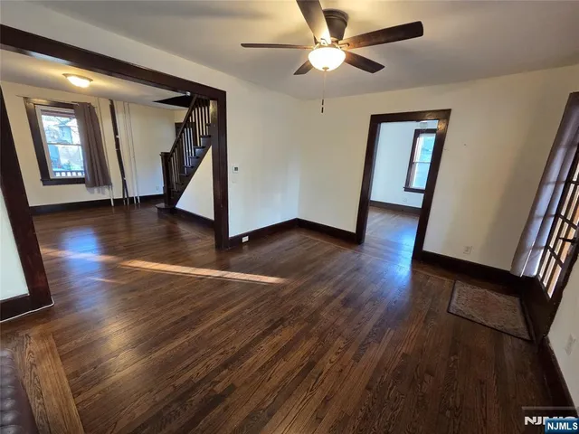a view of a livingroom with wooden floor and a ceiling fan