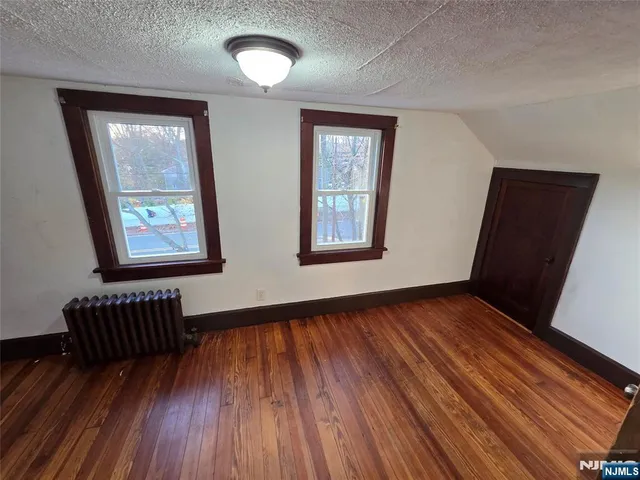 a view of an empty room and wooden floor with windows