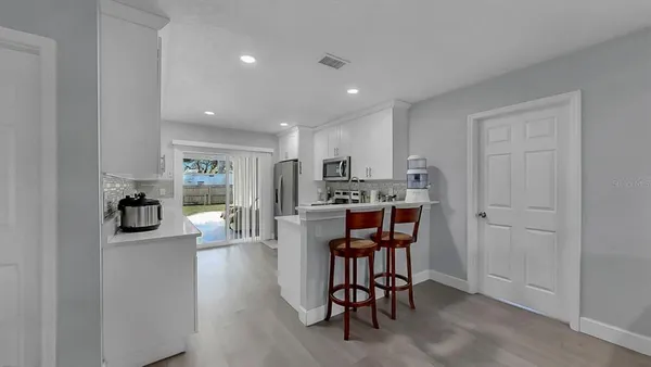 a kitchen with stainless steel appliances kitchen island granite countertop a refrigerator and cabinets
