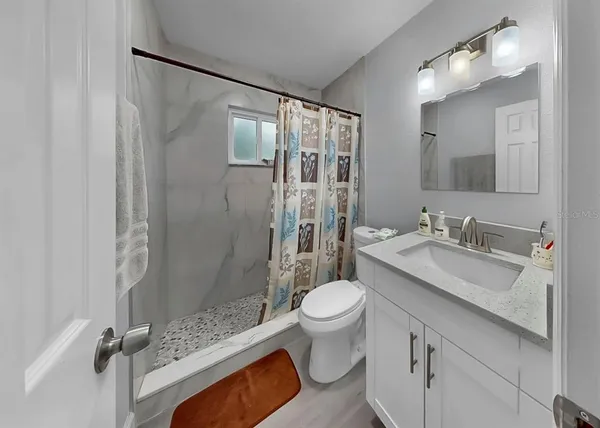 a bathroom with a sink toilet a mirror and shower