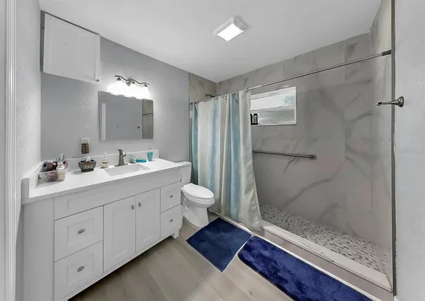 a bathroom with a double vanity sink toilet and shower