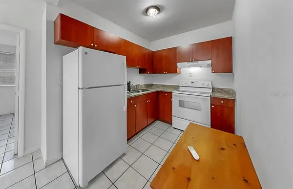 a kitchen with stainless steel appliances granite countertop a refrigerator a sink and a stove