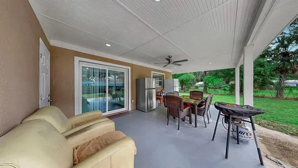 a living room with patio furniture and a large window