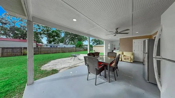 a view of a patio with a table chairs and a yard