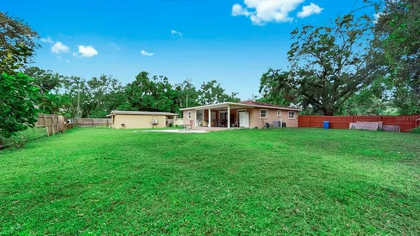 a front view of house with yard and trees in the background
