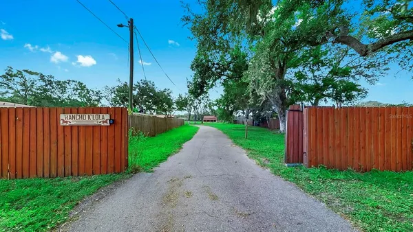 a view of a park with a fence and trees