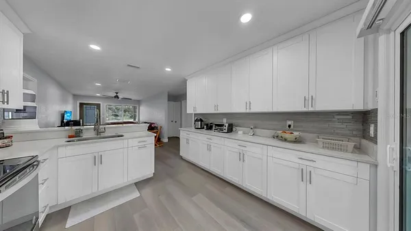a kitchen with white cabinets and sink