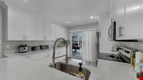 a kitchen with stainless steel appliances granite countertop a sink and a refrigerator