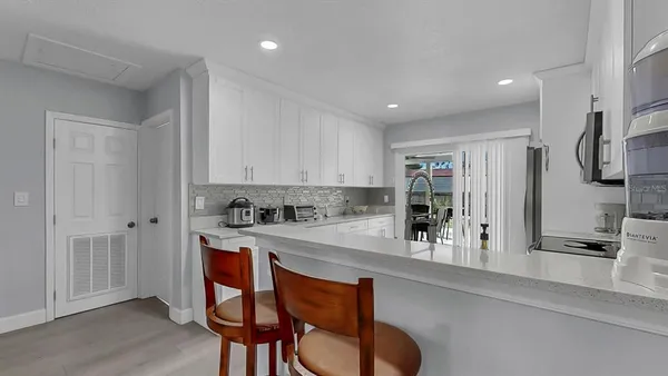 a kitchen with stainless steel appliances granite countertop a sink a stove and a refrigerator