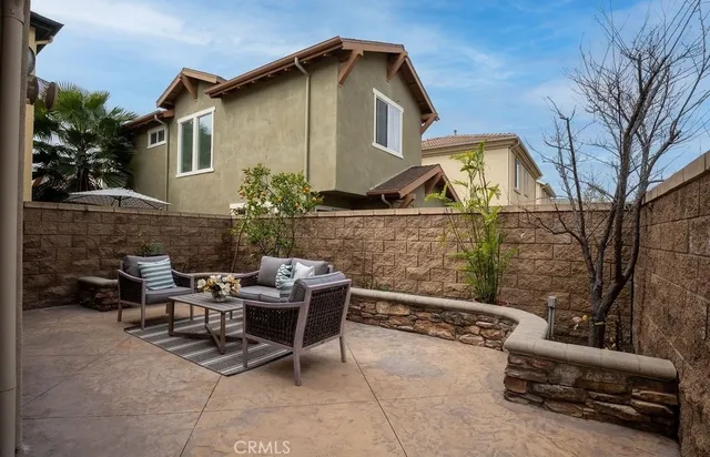 a view of a chairs and table in the back yard of the house