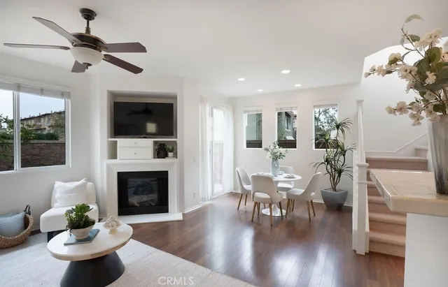 a living room with furniture dining table a fireplace and a potted plant