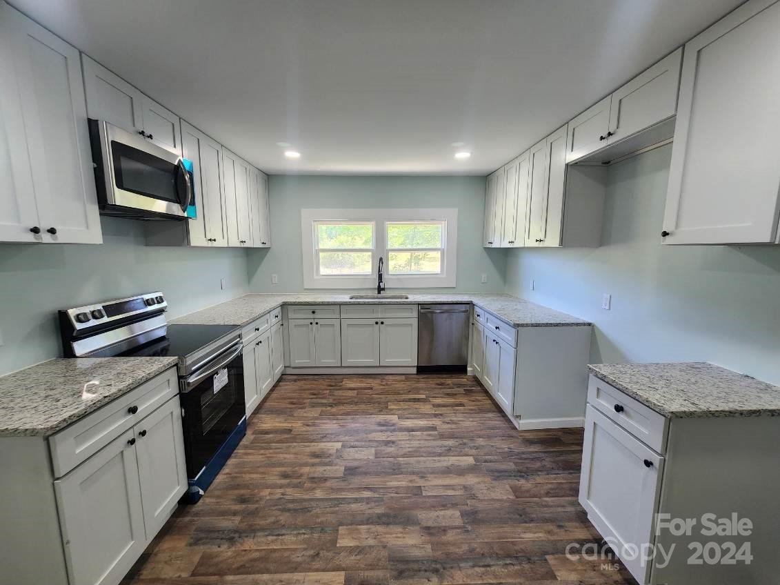 1004 Columbia Road Chester, SC 29706 - Photo 6 of 15 a large kitchen with stainless steel appliances granite countertop a stove top oven a sink dishwasher and a microwave oven on the blue kitchen countertops