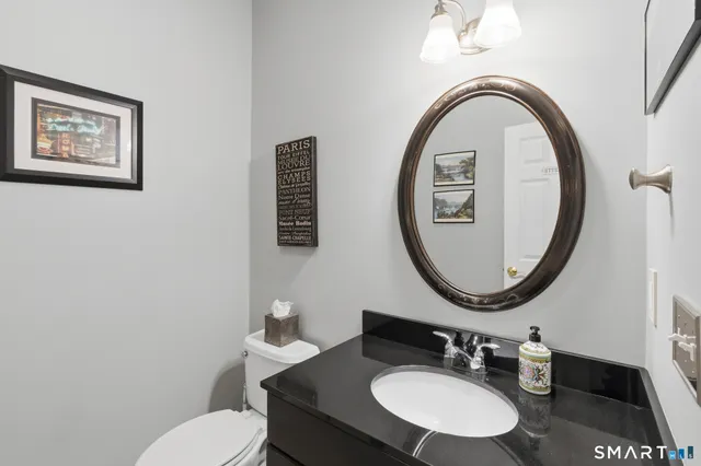 a bathroom with a toilet a sink and a mirror