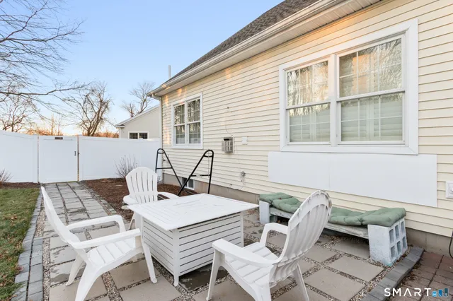 a view of a patio with table and chairs with wooden floor and fence