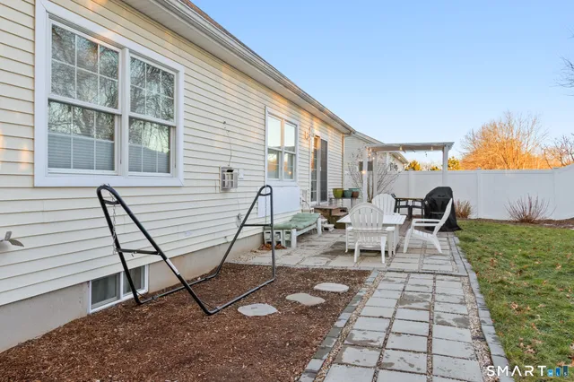 a view of a backyard with table and chairs and wooden fence