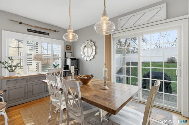 a view of a dining room with furniture large windows and wooden floor