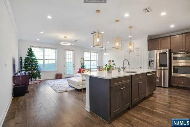 a large kitchen with kitchen island white cabinets and stainless steel appliances