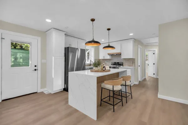 a kitchen with refrigerator cabinets and a sink