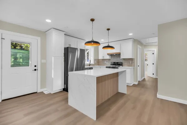 a kitchen with stainless steel appliances a stove a refrigerator a oven a sink and a island