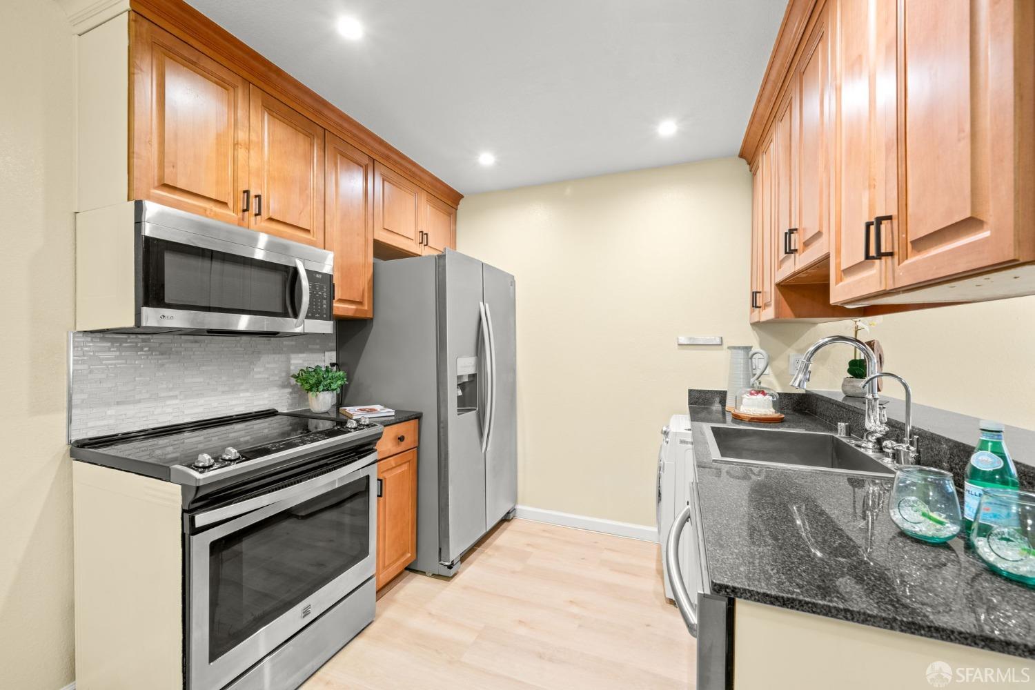7323 Starward Drive, Unit 8 Dublin, CA 94568 - Photo 6 of 21 a kitchen with stainless steel appliances granite countertop a sink stove and refrigerator