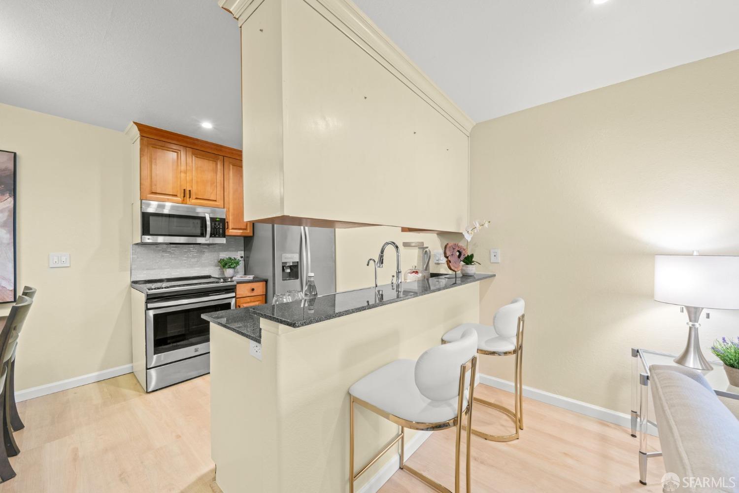 7323 Starward Drive, Unit 8 Dublin, CA 94568 - Photo 9 of 21 a kitchen with stainless steel appliances a stove a microwave a sink and white cabinets