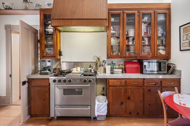 a large kitchen with stainless steel appliances granite countertop a large stove a sink dishwasher and cabinets with wooden floor