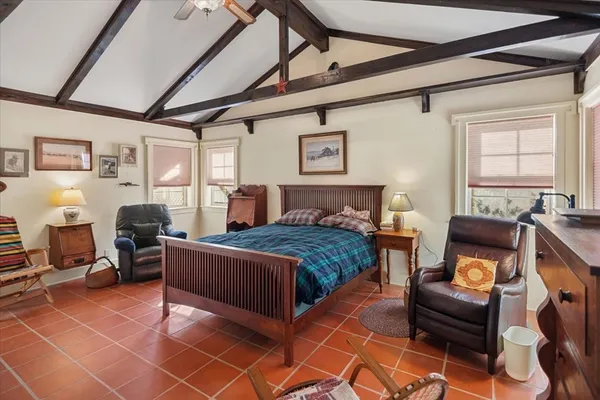 a large bedroom with a bed and wooden floor
