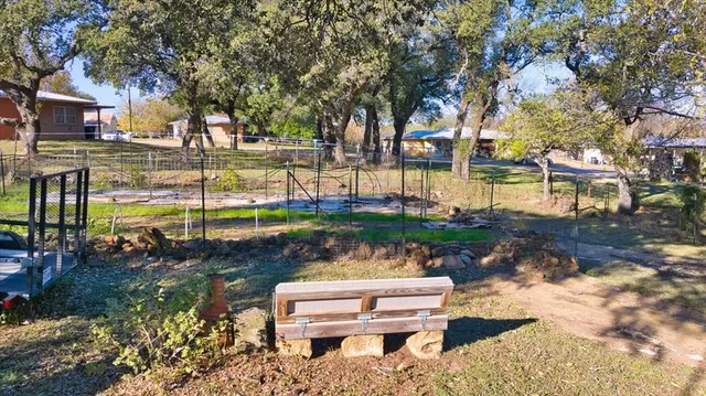 a view of a house with backyard and trees