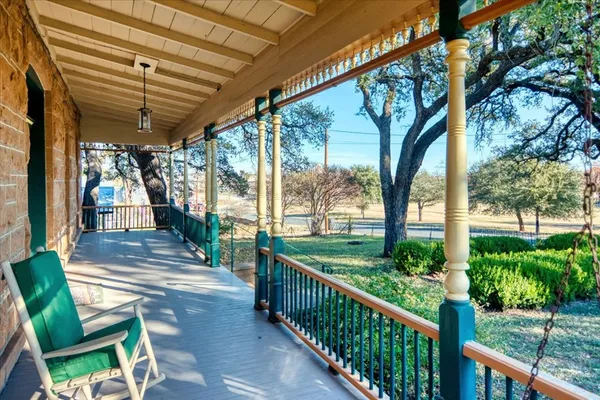 a view of a porch with chairs and floor to ceiling window with wooden fence