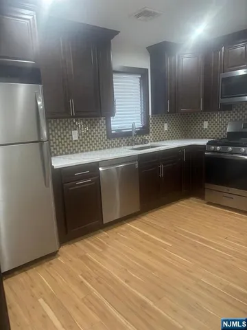a kitchen with stainless steel appliances granite countertop a sink and a stove