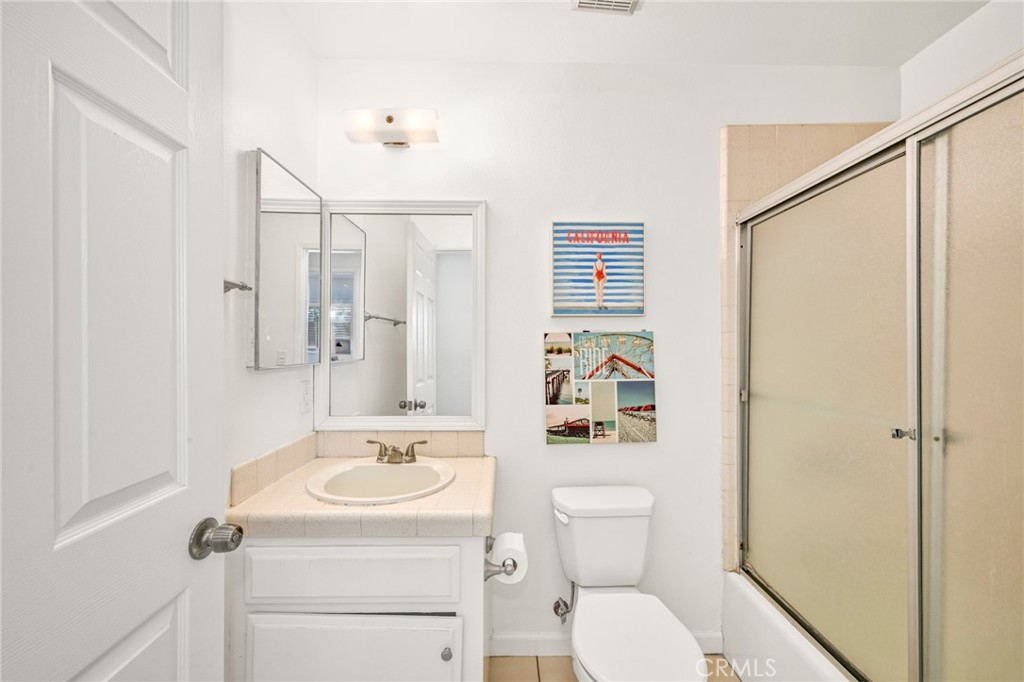 4103 Seashore Drive Newport Beach, CA 92663 - Photo 21 of 62 a bathroom with a sink a toilet and shower curtain