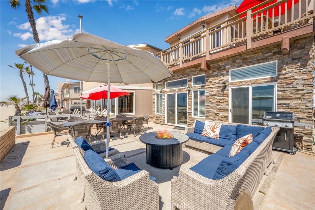 4103 Seashore Drive Newport Beach, CA 92663 - Photo 50 of 62 a view of a patio with couches table and chairs under an umbrella