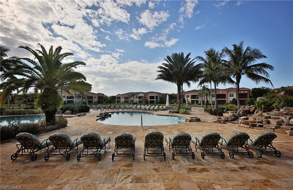22160 Ponte Romano Lane Estero, FL 33928 - Photo 17 of 17 a row of blue swimming pool with lawn chairs under an umbrella