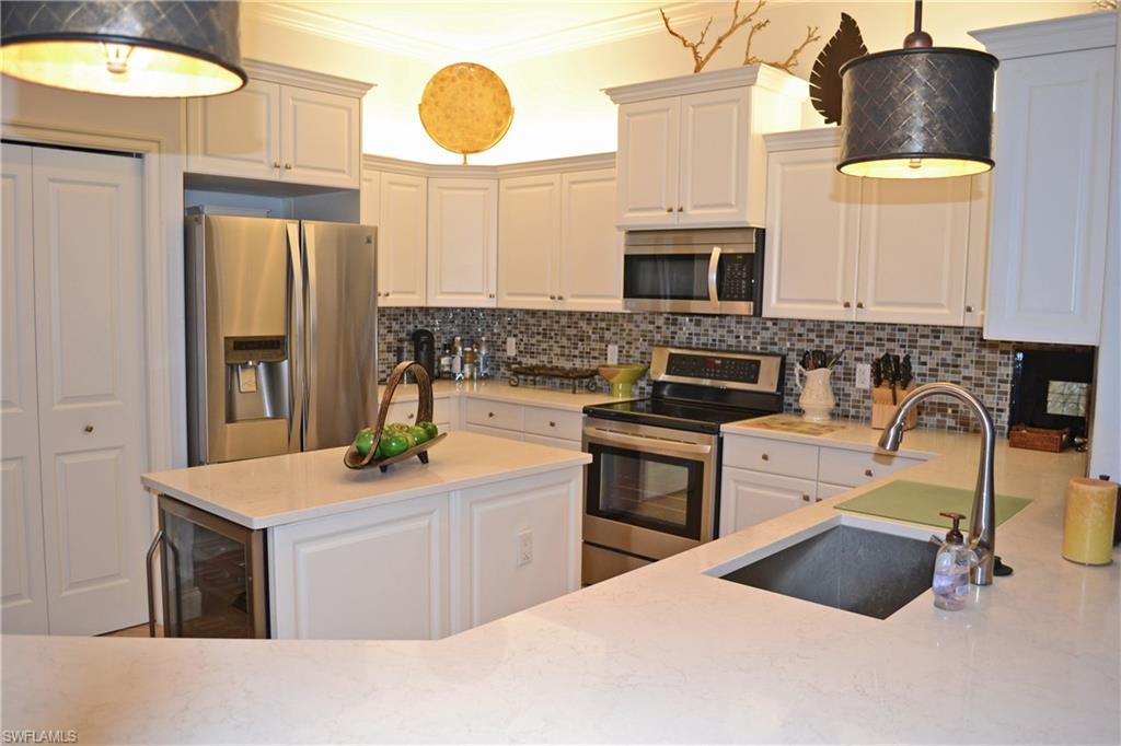 22160 Ponte Romano Lane Estero, FL 33928 - Photo 8 of 17 a kitchen with stainless steel appliances kitchen island granite countertop a sink and a stove