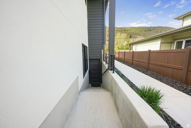 3667 Little Cottonwood Road, Unit 1 Sandy, UT 84092 - Photo 35 of 49 Exterior pathway featuring a concrete walkway, decorative gravel, and a dark brown privacy fence