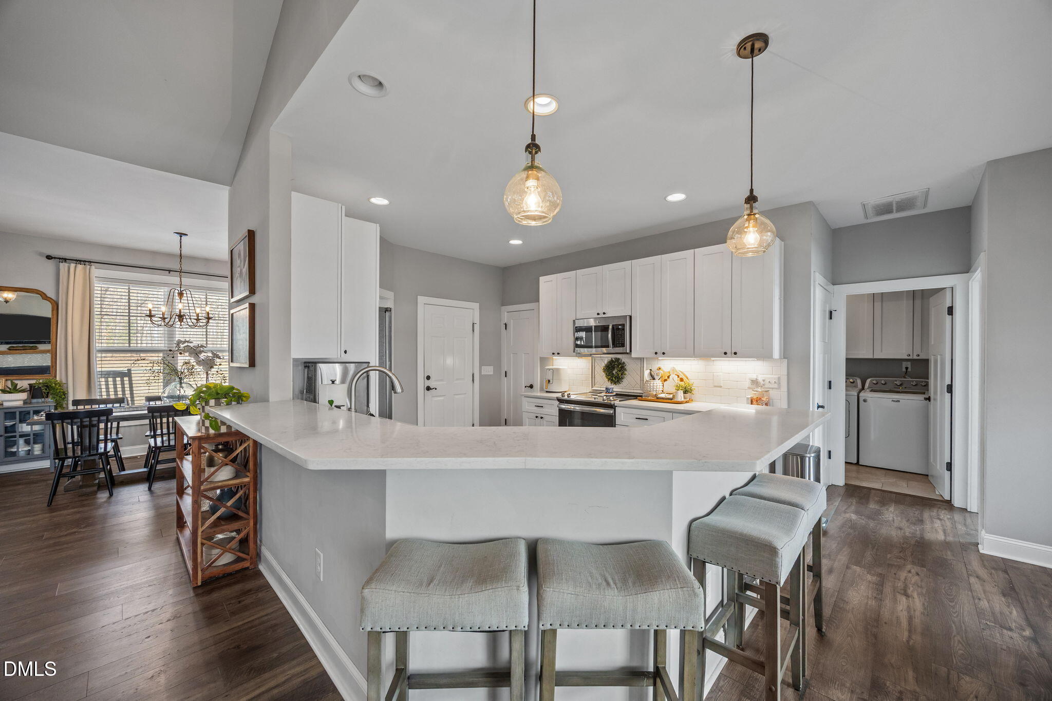 2265 Lacy Holt Road Graham, NC 27253 - Photo 23 of 43 a large kitchen with kitchen island a dining table chairs and a wooden floor