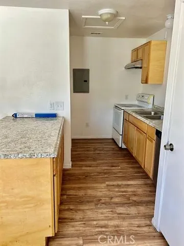 a kitchen with wooden floor and cabinets