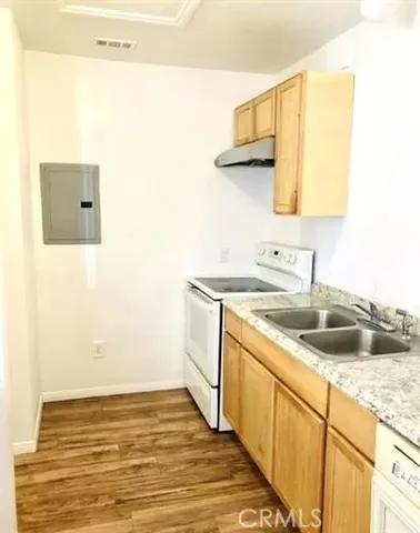 a kitchen with a sink cabinets and a wooden floor
